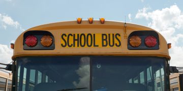 School bus with bold black lettering against a blue sky