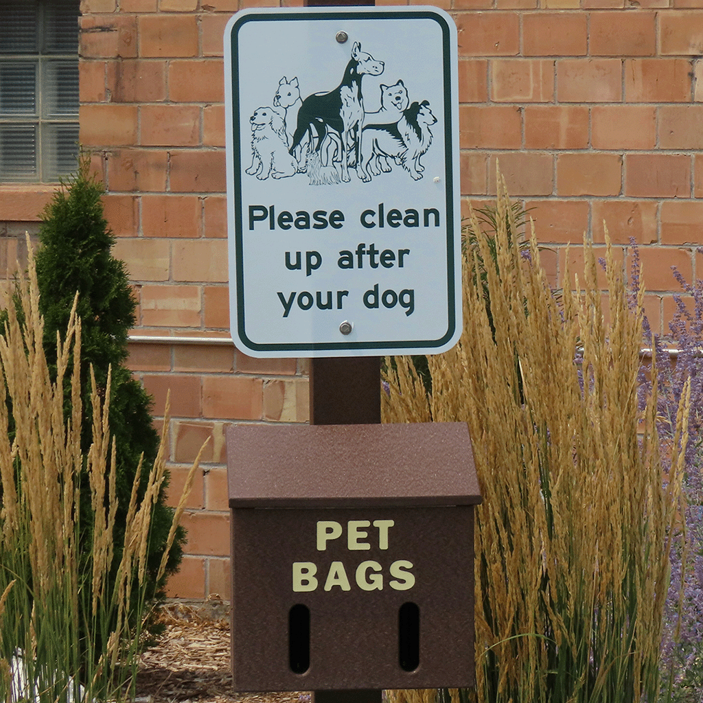 Pet waste bag station with 'Please clean up after your dog' sign