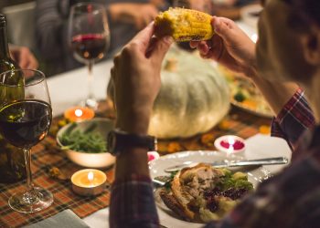 Man eating corn at table on Thanksgiving