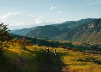 Lady and child walking a grassy trail at Chautauqua Park with mountain views