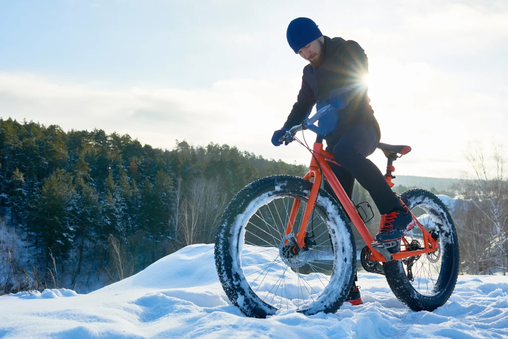 Man riding a fat bike on a snow-covered trail, enjoying outdoor winter activities in Boulder.