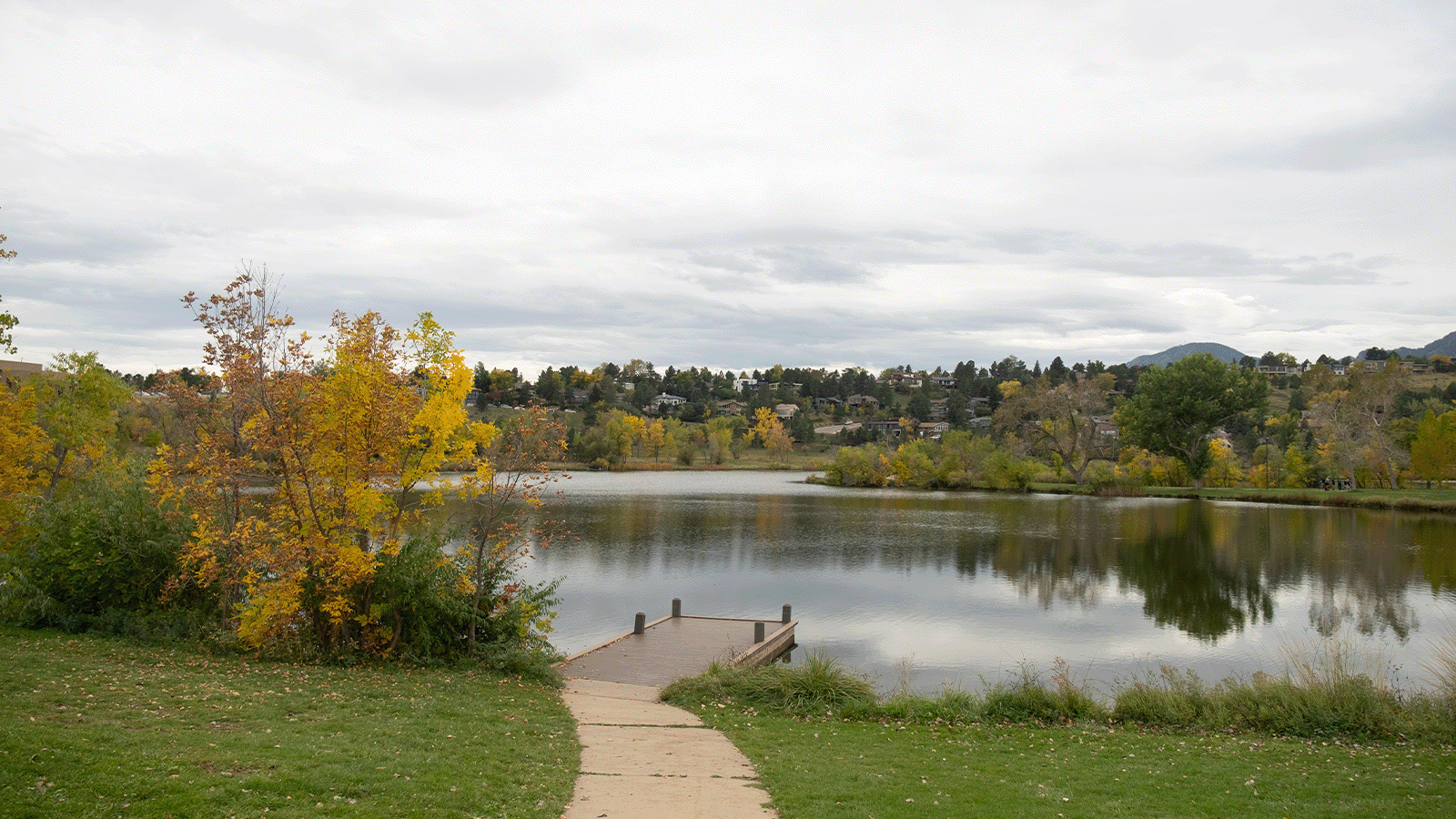 Lakeside park with dock and autumn foliage