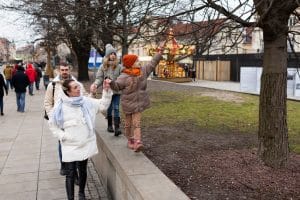 A family walks together in a city park during winter
