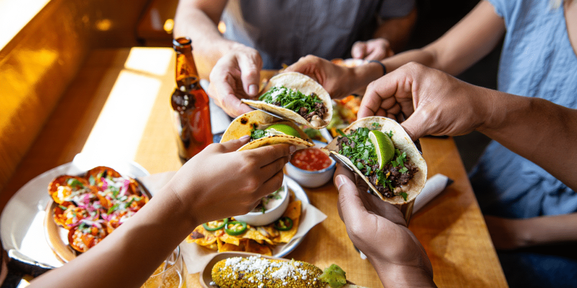 Friends sharing Mexican food tacos at a Boulder Restaurant
