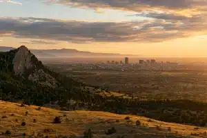 Boulder vs Denver — Flatirons and city skyline at sunset